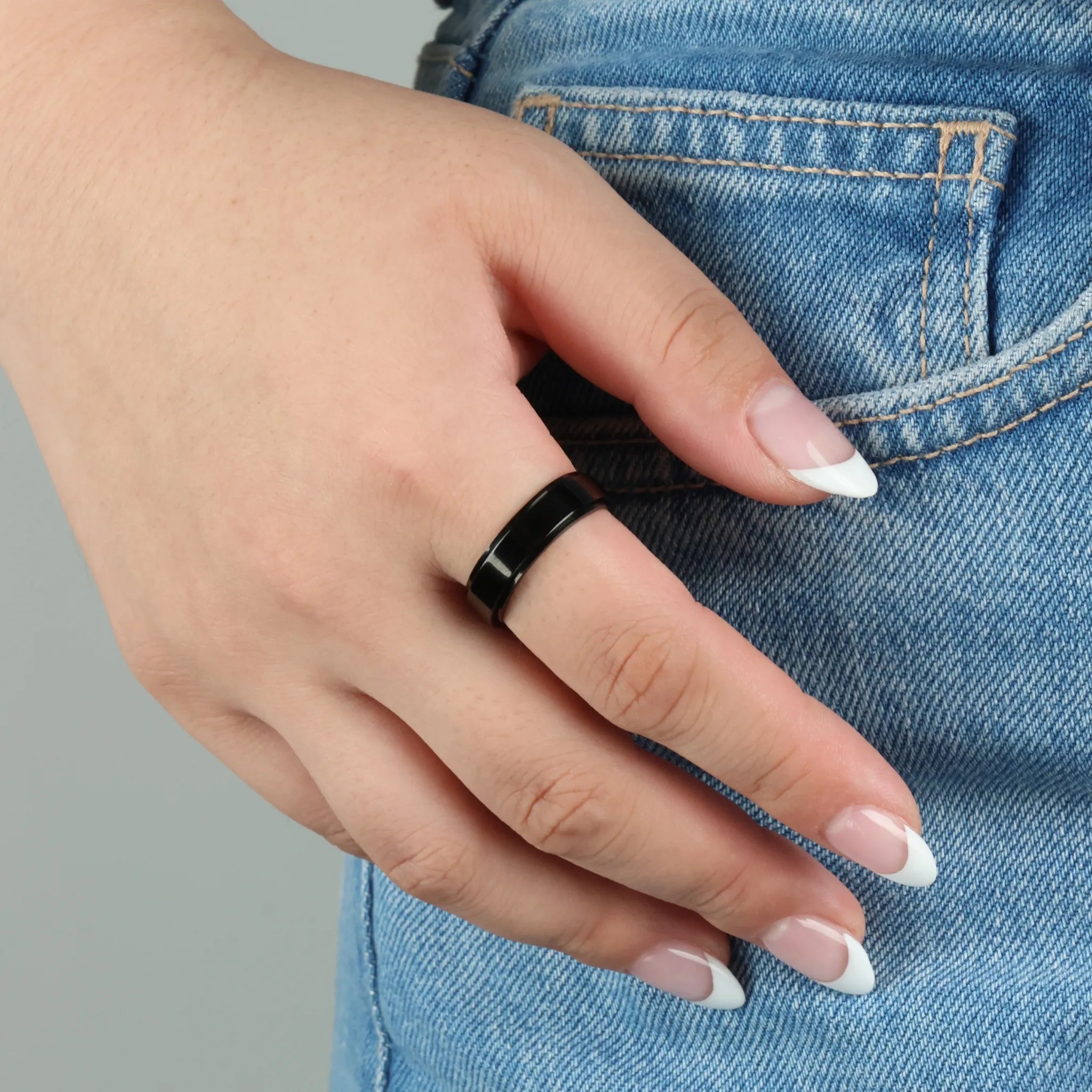 Zwarte Aura fidget ring gedragen bij spijkerbroek, modern uniseks