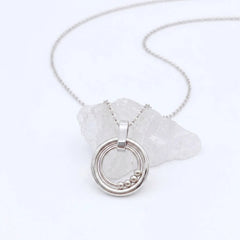 Bead Ketting in zilver van RVS met beweegbare kralen op een witte steen – elegante fidget ketting voor rust en ontspanning.