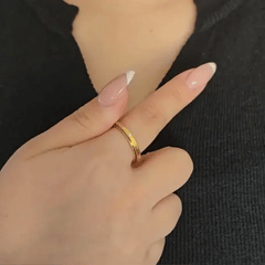 Bewegende weergave van de gouden Infinity fidget ring waarbij de buitenste band soepel en kalmerend ronddraait.