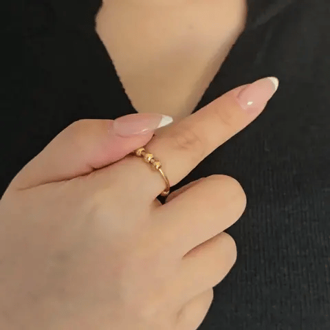 Bewegende weergave van de gouden Ivy Bead fidget ring waarbij de band met afwisselende kraaltjes soepel ronddraait.