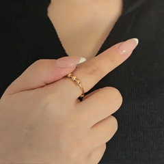 Bewegende weergave van de gouden Ivy Bead fidget ring waarbij de band met afwisselende kraaltjes soepel ronddraait.