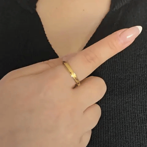 Bewegende weergave van de gouden Prism fidget ring in actie, waarbij de strakke diagonaal gegraveerde band soepel ronddraait.