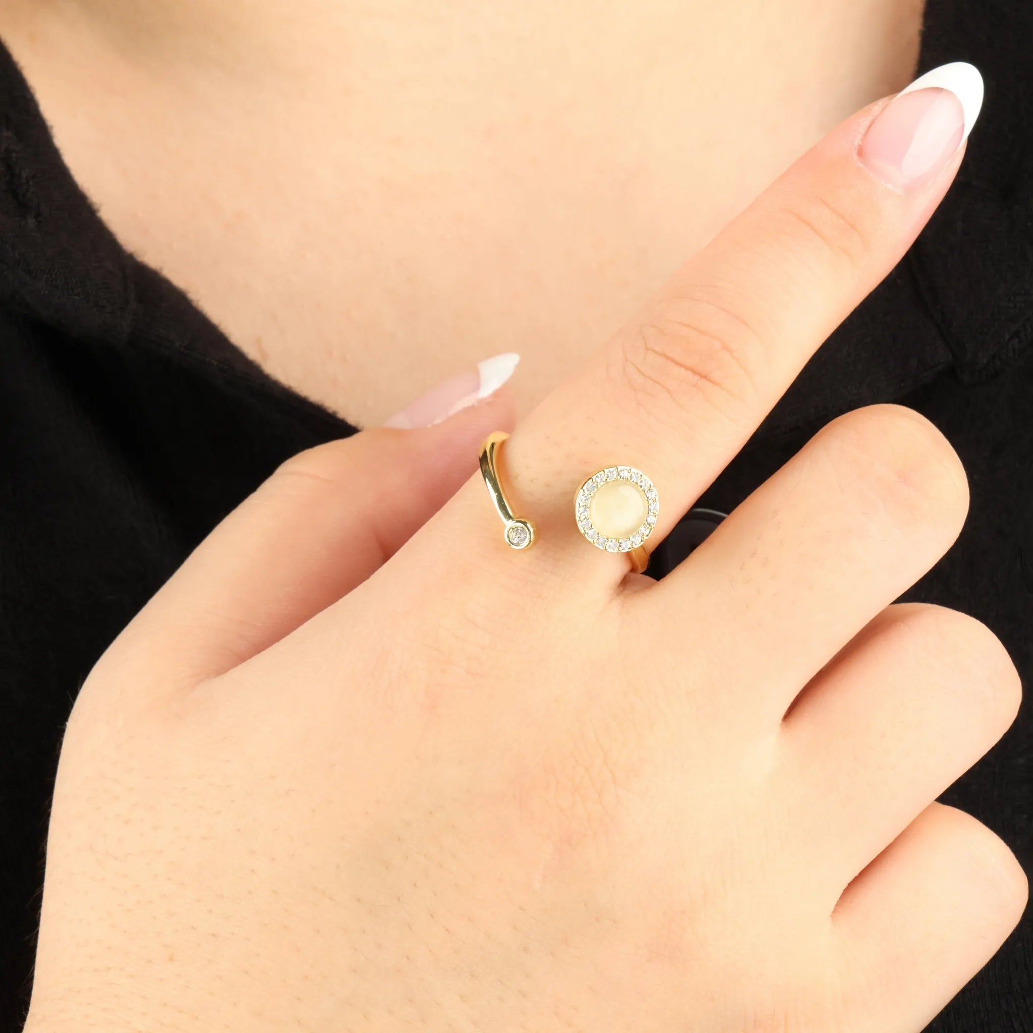 Gouden Opal fidget ring met glanzende afwerking en kristalrand, gedragen bij zwarte top – elegant hulpmiddel voor rustmomenten