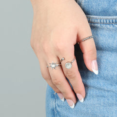 Drie fidget ringen uit de Blissfull Bundel gedragen aan hand op denim jeans, zilverkleurig edelstaal