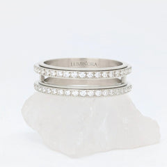 Zilveren Gemini anxiety ring ontworpen met een elegante dubbele rij steentjes, geplaatst op een witte kwartssteen.