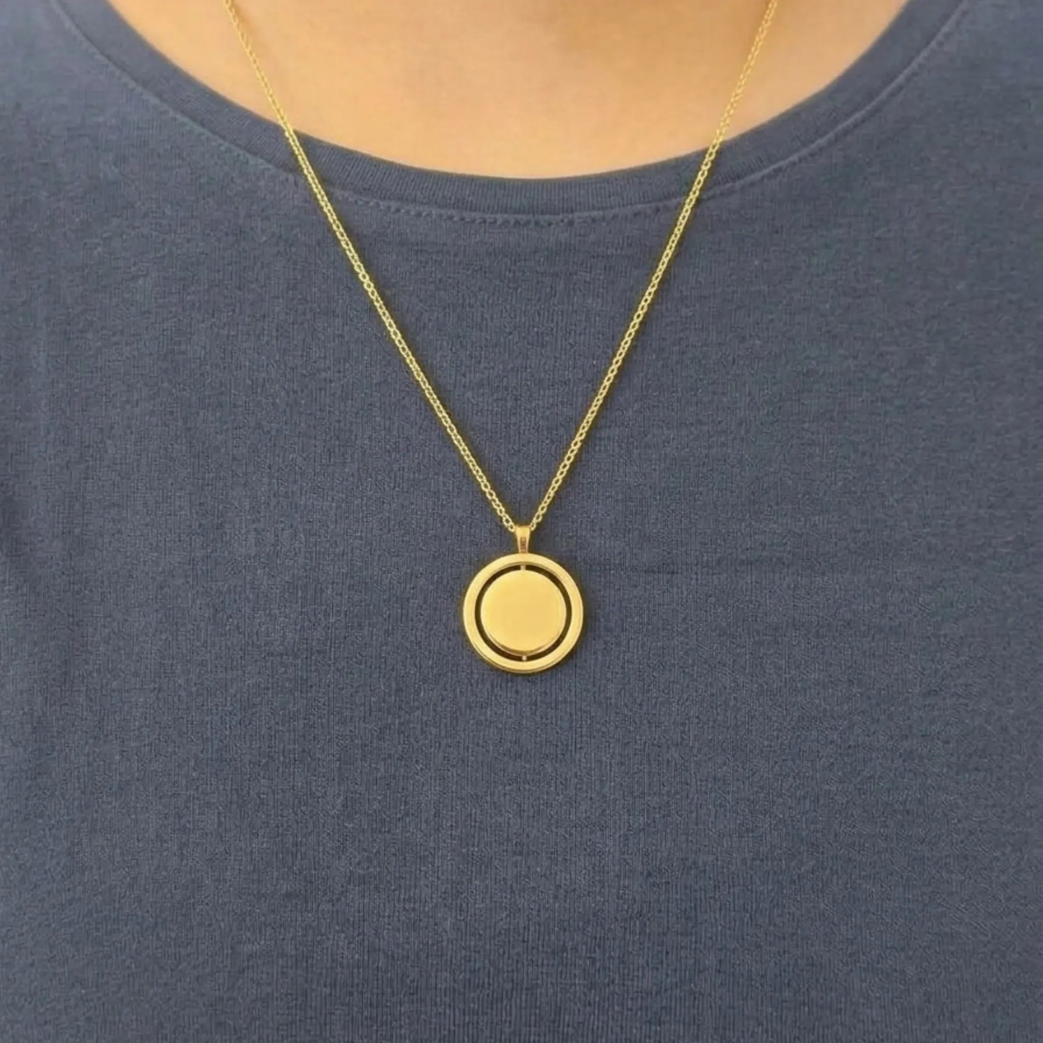 Model met een blauw shirt die de gouden Oracle anxiety ketting van RVS rond de hals draagt.