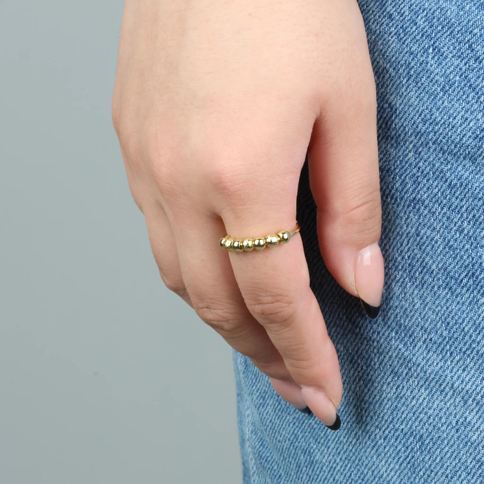 Gouden Ivy Bead fidget ring met geribbelde kralen gedragen bij spijkerbroek – Luminora