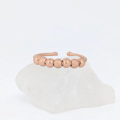Roségouden Ivy Bead fidget ring met subtiele glans en geribbelde kralen op witte steen – Luminora