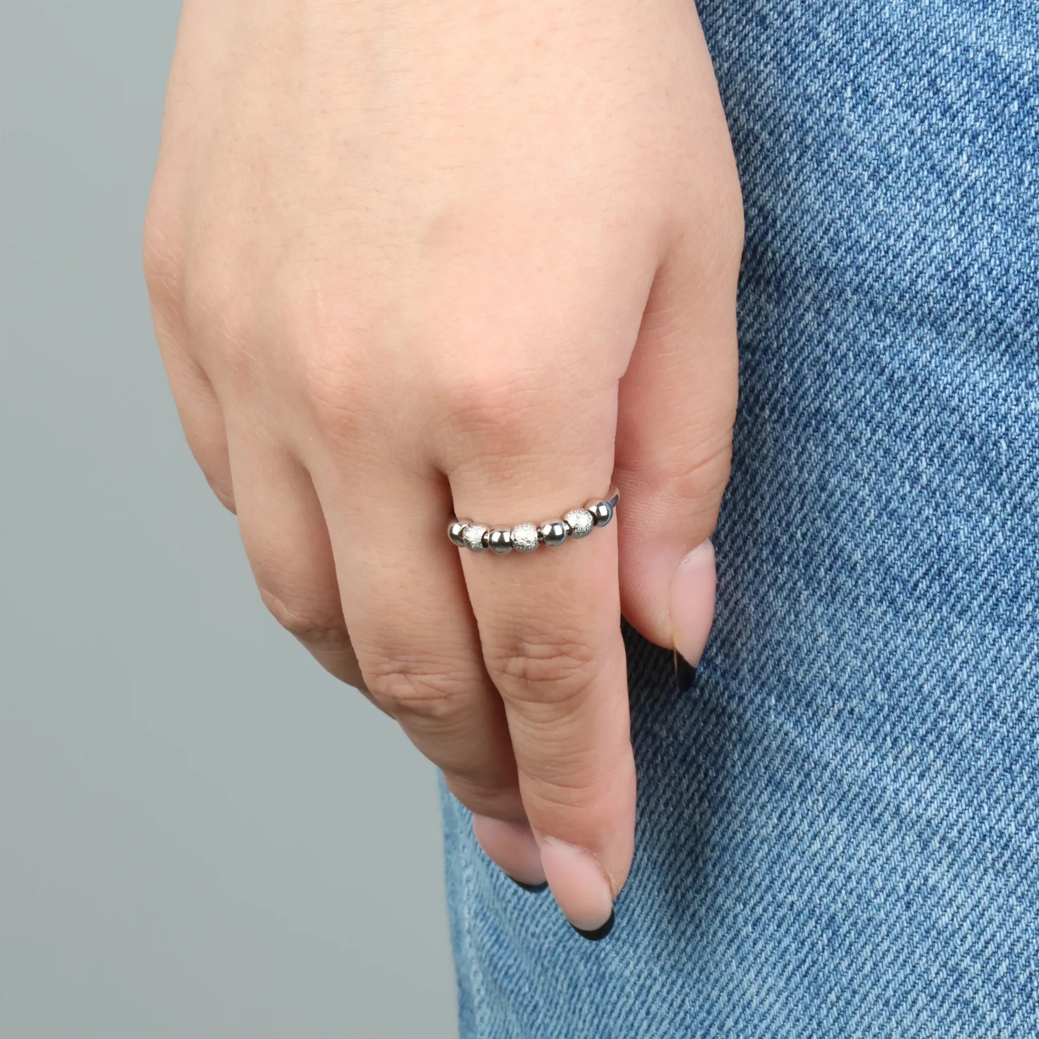 Zilveren Ivy Bead fidget ring met geribbelde kralen gedragen bij spijkerbroek – Luminora