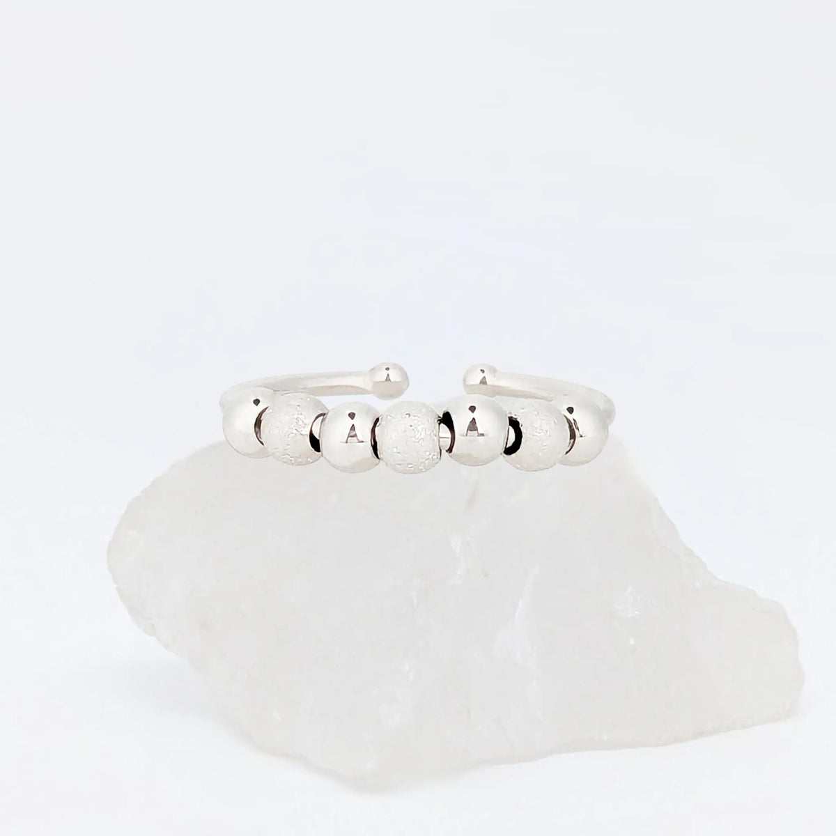 Zilveren Ivy Bead fidget ring met glanzende en geribbelde kralen op witte steen – Luminora