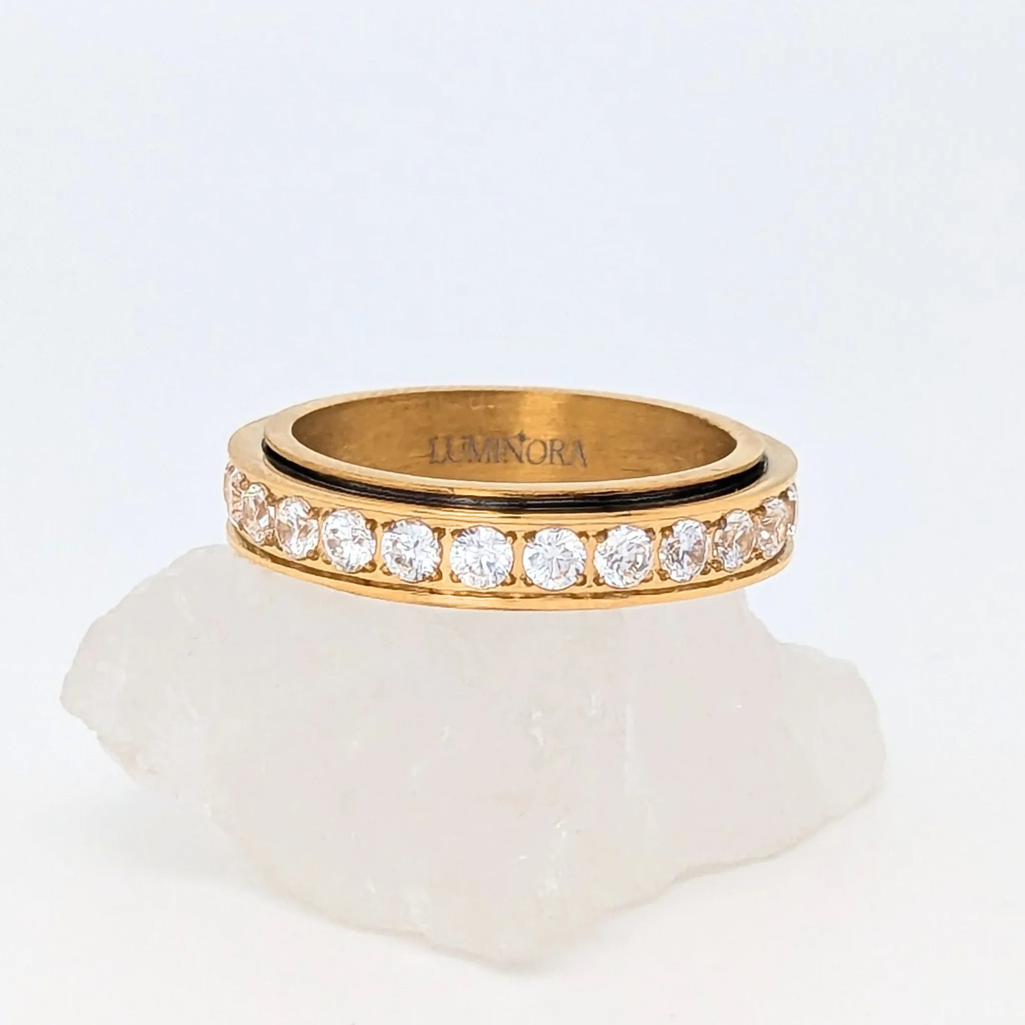 Gouden Liora fidget ring van edelstaal met ronde witte kristallen en glanzende afwerking – Luminora