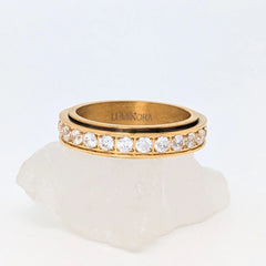 Gouden Liora fidget ring van edelstaal met ronde witte kristallen en glanzende afwerking – Luminora