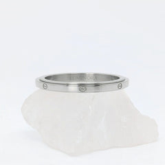 Zilveren Marea anxiety ring gekenmerkt door een strak design met subtiele golfmotieven, geplaatst op een witte kwartssteen.