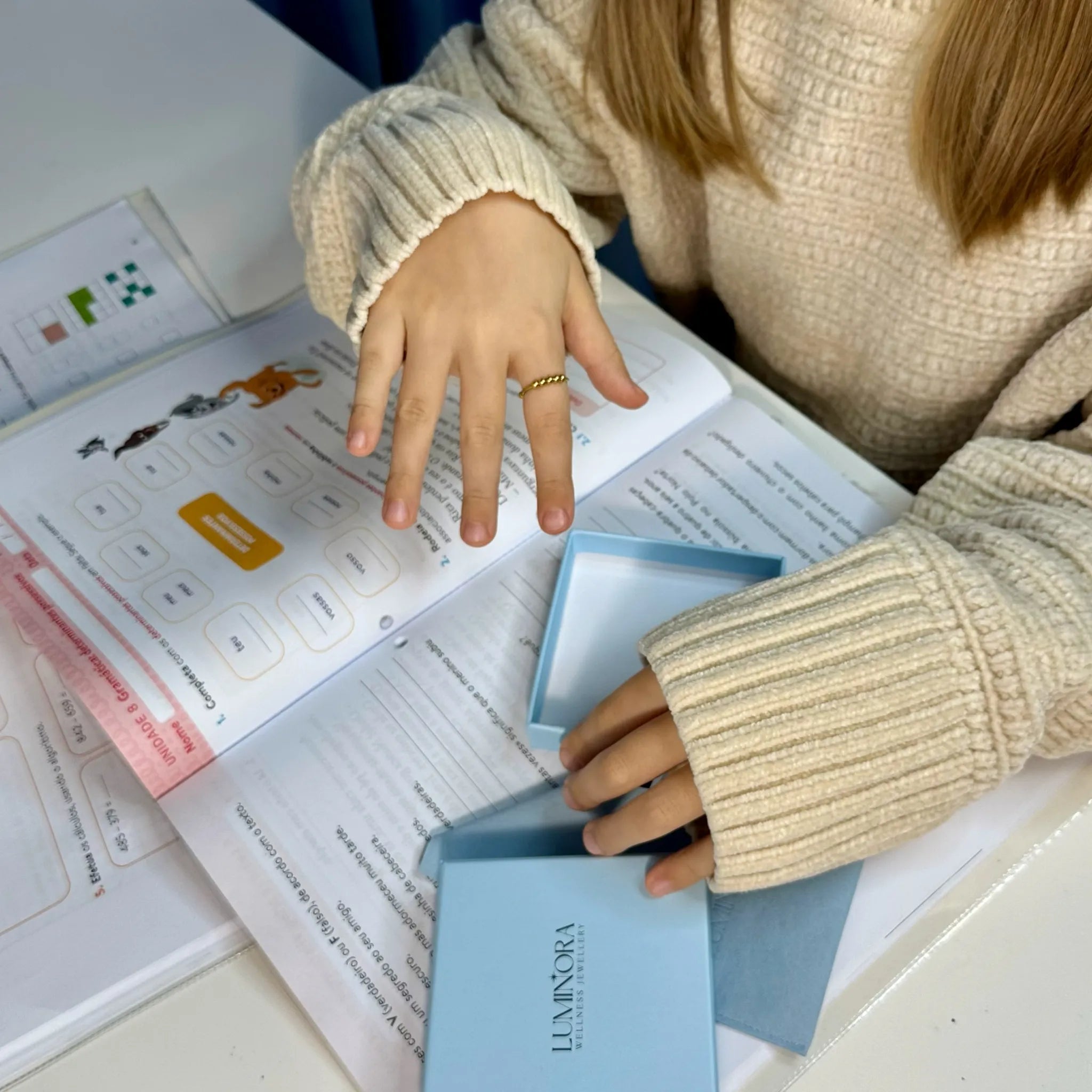 Meisje gebruikt Kids Bead fidget ring tijdens schoolwerk voor focus en rust – Luminora