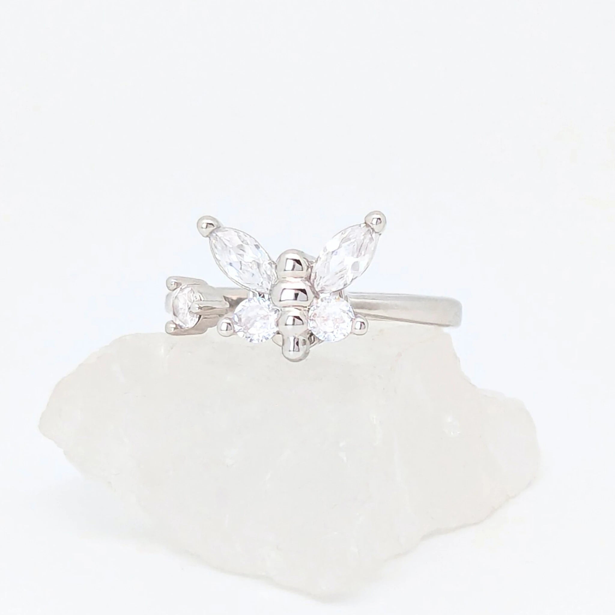 Zilveren Nabi fidget ring in de vorm van een vlinder met heldere zirkonia kristallen, gepresenteerd op een witte steen.