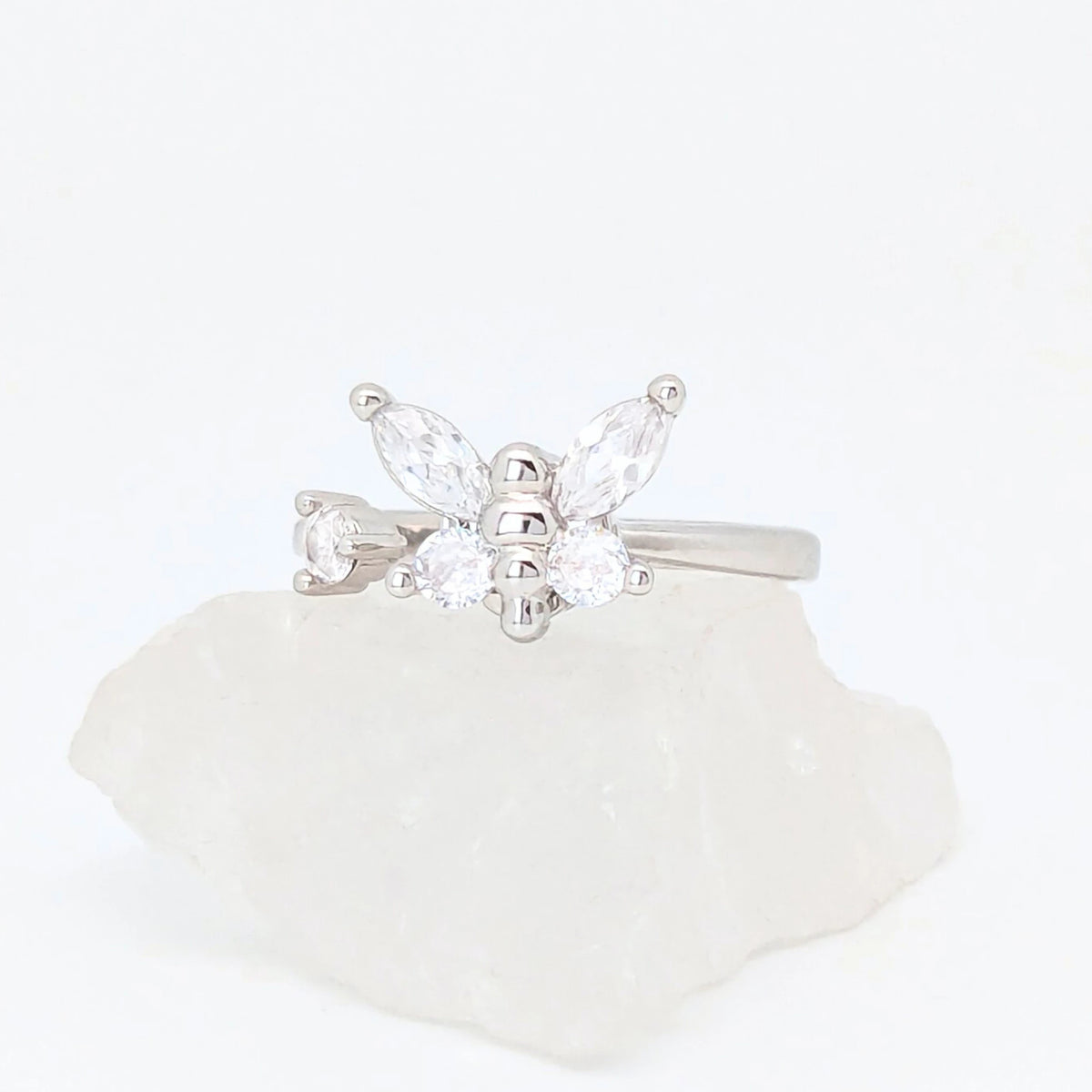Zilveren Nabi fidget ring in de vorm van een vlinder met heldere zirkonia kristallen, gepresenteerd op een witte steen.