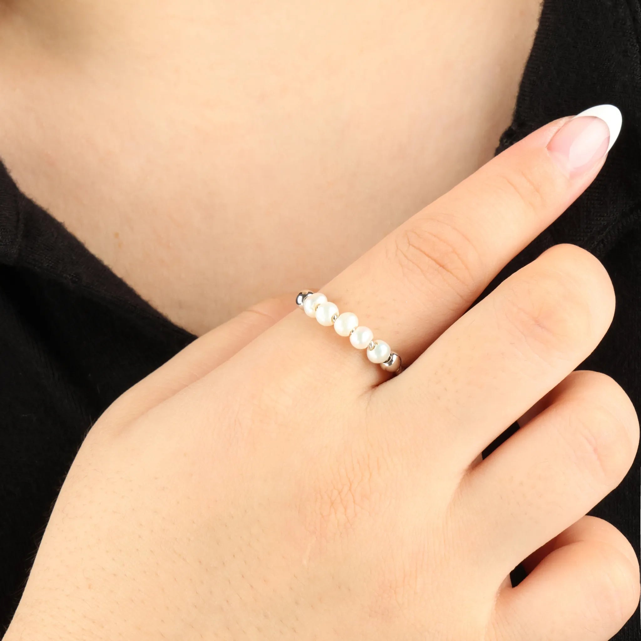Zilveren Pearl anxiety ring met parels gedragen bij zwart shirt