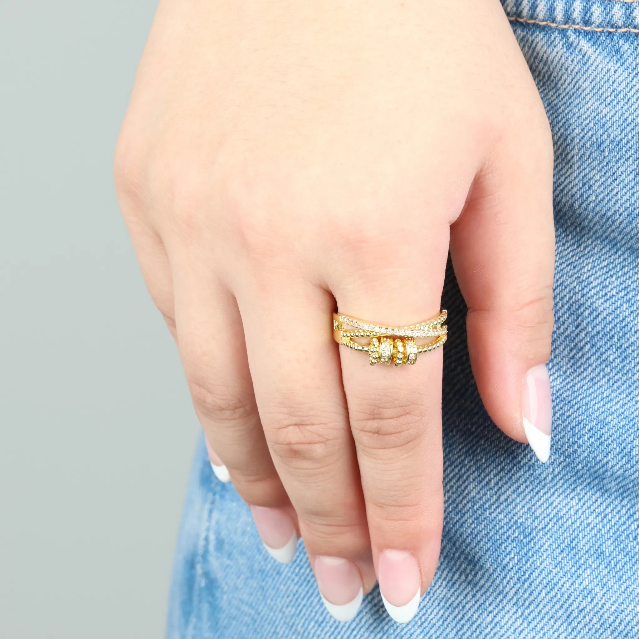 Vrouw draagt gouden Serenity fidget ring met witte steentjes – stijlvol en ontspannend – Luminora