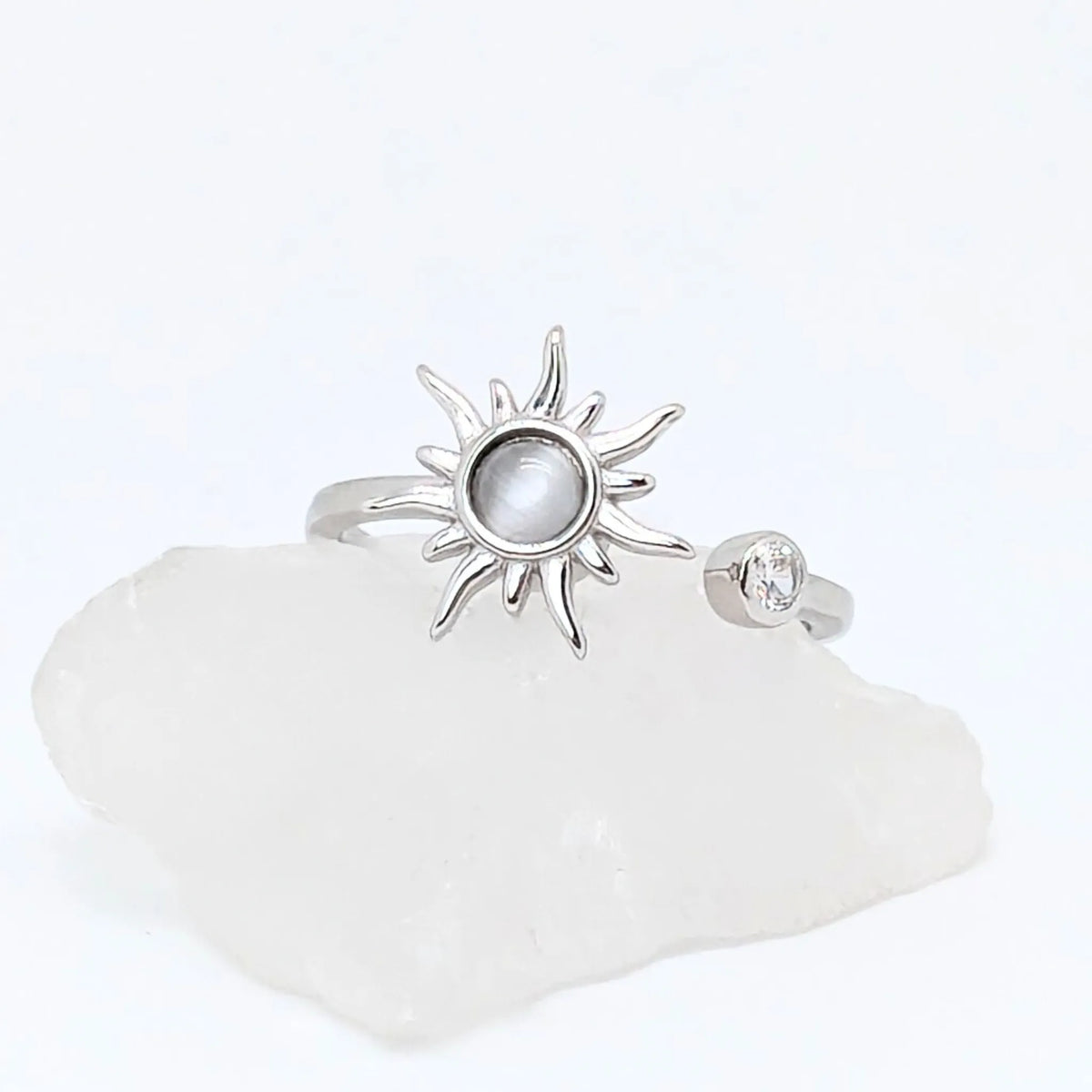 Close-up van verstelbare zilveren Solar wellness ring met zonvormig design en glanzende steen – symbool van energie en innerlijke rust